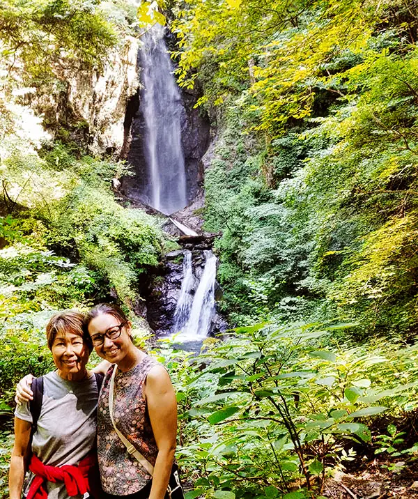 Waterfall in forest landscape in Yamanashi Japan with hikers enjoying nature